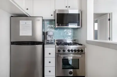 a kitchen with a stainless steel refrigerator and a microwave at Pacific Villas in Oceanside