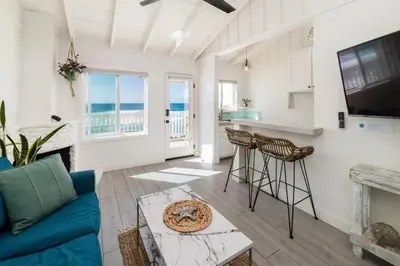 a living room with a fireplace and a blue couch at Pacific Villas in Oceanside