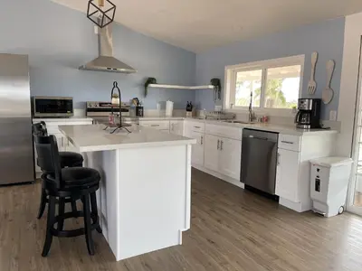 a kitchen with white cabinets and a large island at Temecula Rejuvenation in Temecula