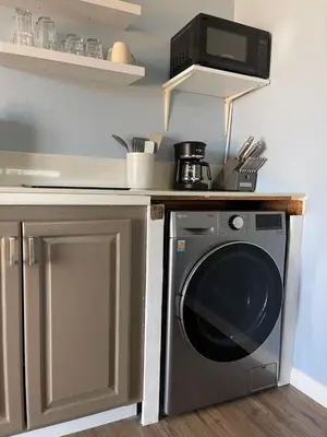 a kitchen with a washing machine under a microwave at Rejuvenation Cottage - Wine Country Tranquility in Temecula