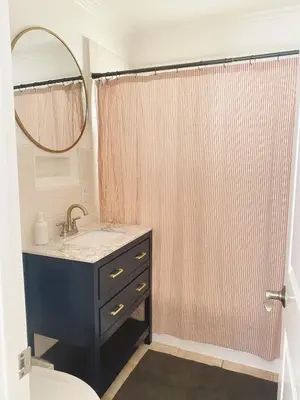 a bathroom with a sink and a shower with a mirror at Beach house in the heart of balboa peninsula in Newport Beach