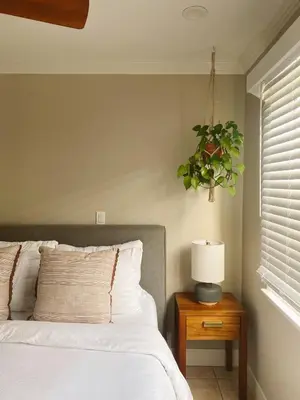 a bedroom with a bed with a lamp and a plant at Beach house in the heart of balboa peninsula in Newport Beach