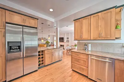 a kitchen with wooden cabinets and a stainless steel refrigerator at Spacious San Diego House with Yard and Patio! in San Diego