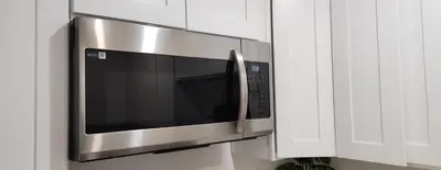 a stainless steel microwave in a white kitchen at Gated Mountain Villa w/ Private Garage and King Bed in Lake Elsinore