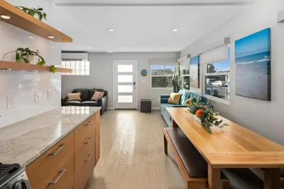a kitchen and living room with a table and a couch at Newly Renovated 3BR Modern Apt in Heart of Ocean Beach in San Diego
