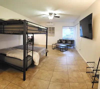 a bedroom with a bunk bed and a living room at Private, Spacious, 4x Queen, 300 MBPS Internet with Backyard! in Hemet
