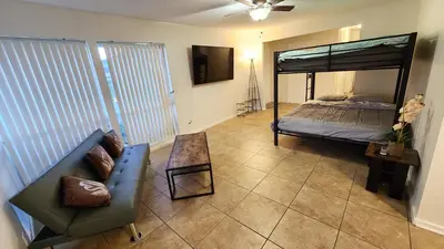 a living room with a bed and a couch at Private, Spacious, 4x Queen, 300 MBPS Internet with Backyard! in Hemet