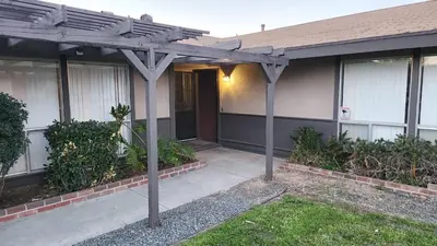 a house with a wooden pergola in front of it at Private, Spacious, 4x Queen, 300 MBPS Internet with Backyard! in Hemet