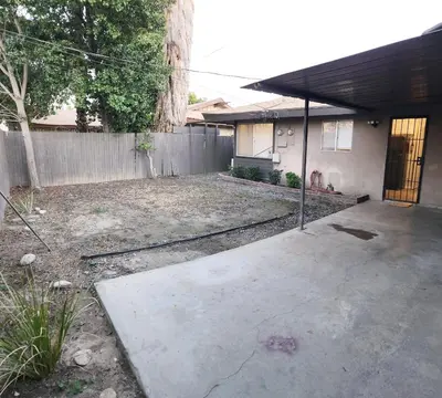 an empty backyard with a fence and a house at Private, Spacious, 4x Queen, 300 MBPS Internet with Backyard! in Hemet