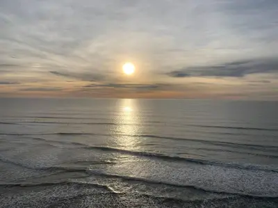 a sunset over the ocean with the sun in the sky at Steps To The BEST Beach . Surf . Spa . Main Street in Encinitas