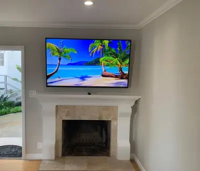 a living room with a flat screen tv on a fireplace at Steps To The BEST Beach . Surf . Spa . Main Street in Encinitas