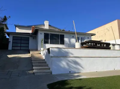 a white house with a white wall and stairs at Steps To The BEST Beach . Surf . Spa . Main Street in Encinitas