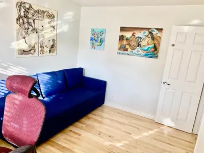 a blue couch in a room with paintings on the wall at Artsy smart home near Downtown & Balboa Park in San Diego