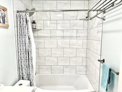 a white bathroom with a tub and a shower at Artsy smart home near Downtown & Balboa Park in San Diego