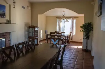 a dining room with a table and chairs at Private Home on 10 Acres - Heated Salt Pool & Jacuzzi, Mountain & City Views, Horseshoes, Basketball, BBQ, Golf Putting, Foosball, Croquet, Bose Stereo, White Cotton Bedding - Hilltop Hacienda, Pool Heat Optional in Jamul