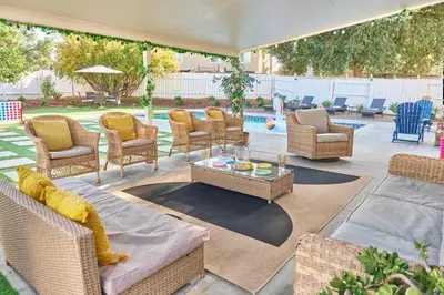 a patio with wicker chairs and tables and a pool at Entire Mountain Oasis Home in Hemet