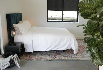 a bedroom with a bed with white sheets and a window at Hidden Hacienda in Temecula