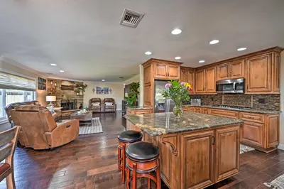 a large kitchen with wooden cabinets and a counter top at Vista Home with Pool about 11 Mi to Tamarack State Beach in Vista