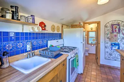 a kitchen with a sink and a white refrigerator at Cozy Story Book Barn Cottage with Scenic View in Julian