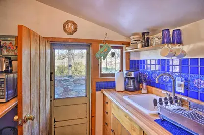 a kitchen with blue tiled walls and a sink at Cozy Story Book Barn Cottage with Scenic View in Julian
