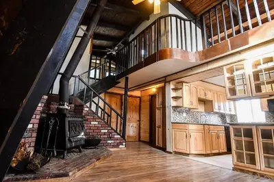 a large room with a staircase and a stove at Julian House of Games in Julian