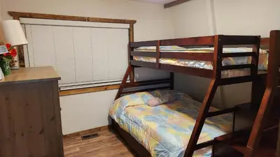 a bedroom with two bunk beds and a desk at Julian House of Games in Julian