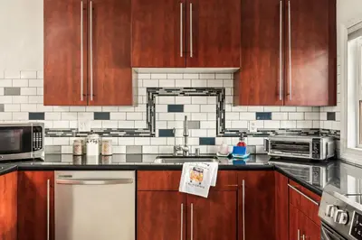 a kitchen with wooden cabinets and a stove top oven at Beach Front Bungalow at Pacific Beach in San Diego