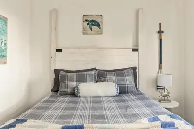 a bedroom with a bed with a blanket and pillows at Beach Front Bungalow at Pacific Beach in San Diego