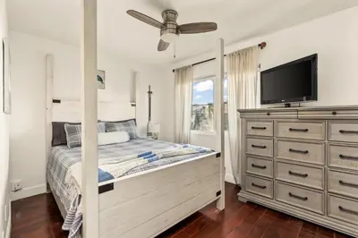 a bedroom with a bed with a tv and a dresser at Beach Front Bungalow at Pacific Beach in San Diego