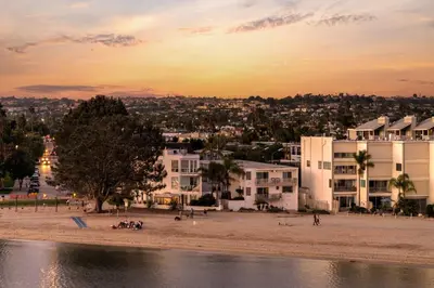 a view of a beach at sunset with buildings at Beach Front Bungalow at Pacific Beach in San Diego