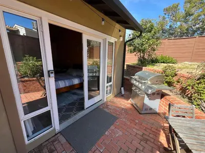 a patio with sliding glass doors and a grill at On Site Parking King Master Suite UCSD Walk in San Diego