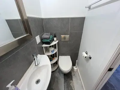 a bathroom with a white toilet and a sink at On Site Parking King Master Suite UCSD Walk in San Diego