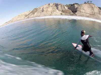 a person riding a wave on a surfboard in the water at Private Room3 Own Entry Shared Bath One Guest Walk to UCSD in San Diego