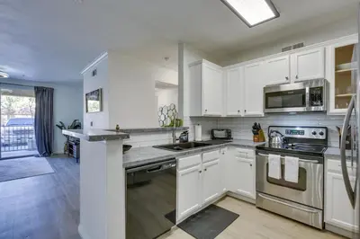 a kitchen with white cabinets and stainless steel appliances at Modern Pet-Friendly San Diego Vacation Rental in San Diego
