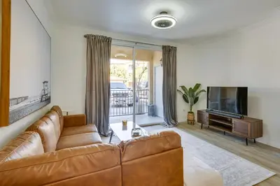 a living room with a brown leather couch and a television at Modern Pet-Friendly San Diego Vacation Rental in San Diego
