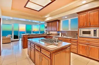 a large kitchen with wooden cabinets and a microwave at Celebrity Oceanfront Estate in San Diego