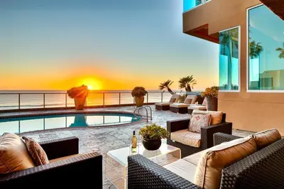 a patio with a swimming pool with chairs and a table at Celebrity Oceanfront Estate in San Diego