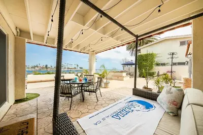 a patio with a couch and a table and chairs at On The Beach Casa in San Diego