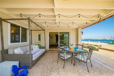 a patio with a table and chairs and a couch at On The Beach Casa in San Diego