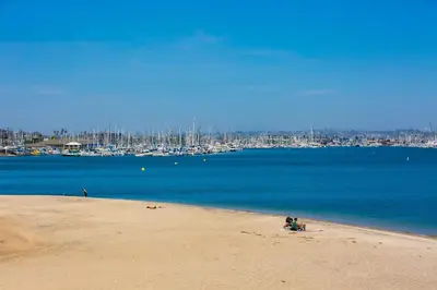 a couple of people sitting on the beach at On The Beach Casa in San Diego