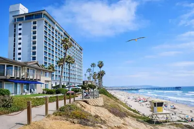 a beach with a tall building and people on the beach at Ocean View Luxury Condo Oceanfront and Pool in San Diego