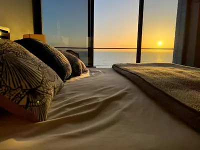 a bed with pillows on it with a view of the ocean at Ocean View Luxury Condo Oceanfront and Pool in San Diego