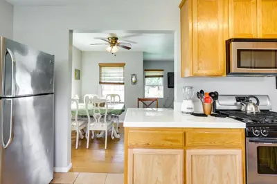 a kitchen with wooden cabinets and a stainless steel refrigerator at Pet-Friendly San Diego Home with Patio 5 Mi to Dtwn in San Diego