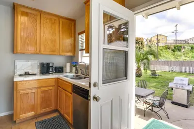 a kitchen with wooden cabinets and a sink at Pet-Friendly San Diego Home with Patio 5 Mi to Dtwn in San Diego