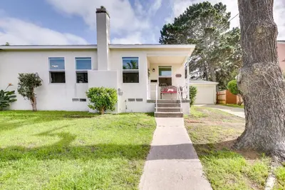 a white house with a tree in front of it at Pet-Friendly San Diego Home with Patio 5 Mi to Dtwn in San Diego
