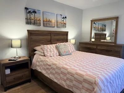 a bedroom with a bed and a dresser and a mirror at Smashing Newly-Built with Ocean/Bay/City Views! in San Diego