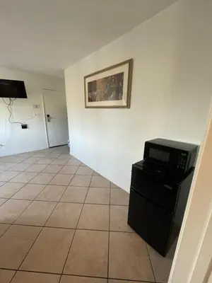 a room with a microwave and a tiled floor at Crown Inn & Suites in Spring Valley