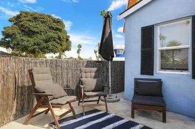 two chairs and an umbrella next to a house at 210 Forty Fourth Street in Newport Beach