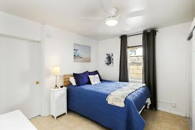 a bedroom with a blue bed and a ceiling fan at 210 Forty Fourth Street in Newport Beach