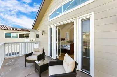 a patio with a couch and chairs on a balcony at 821 West Bay Avenue in Newport Beach